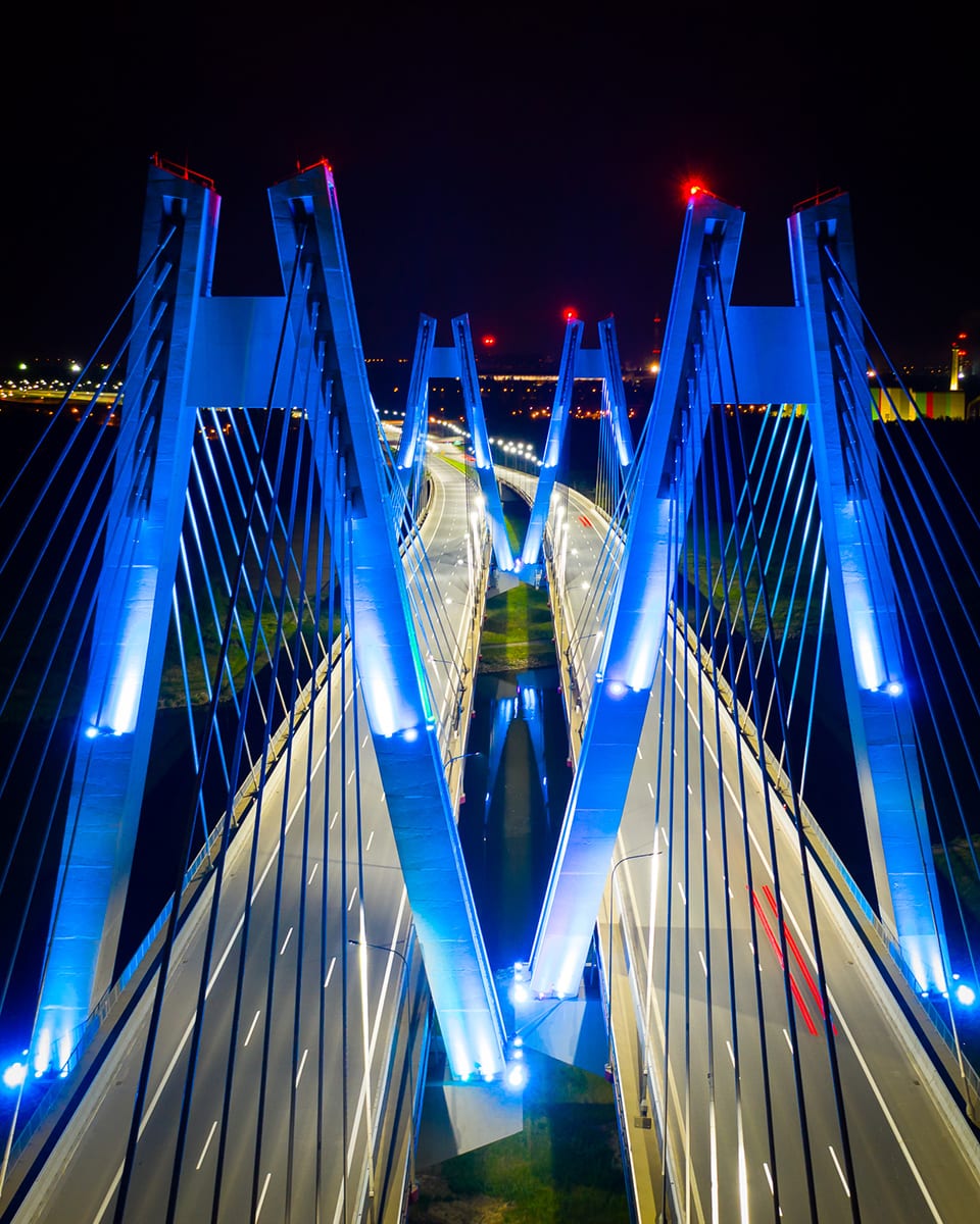 Most na Wiśle nocą oświetlony na niebiesko w ujęciu z drona Kaktus.studio