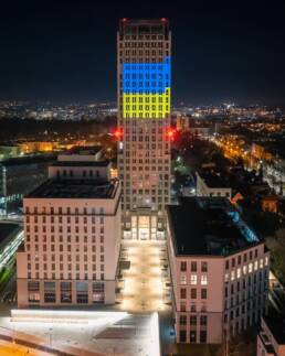 Budynek Unity Centre w Krakowie w nocy z podświetleniem w kolorach flagi Ukrainy