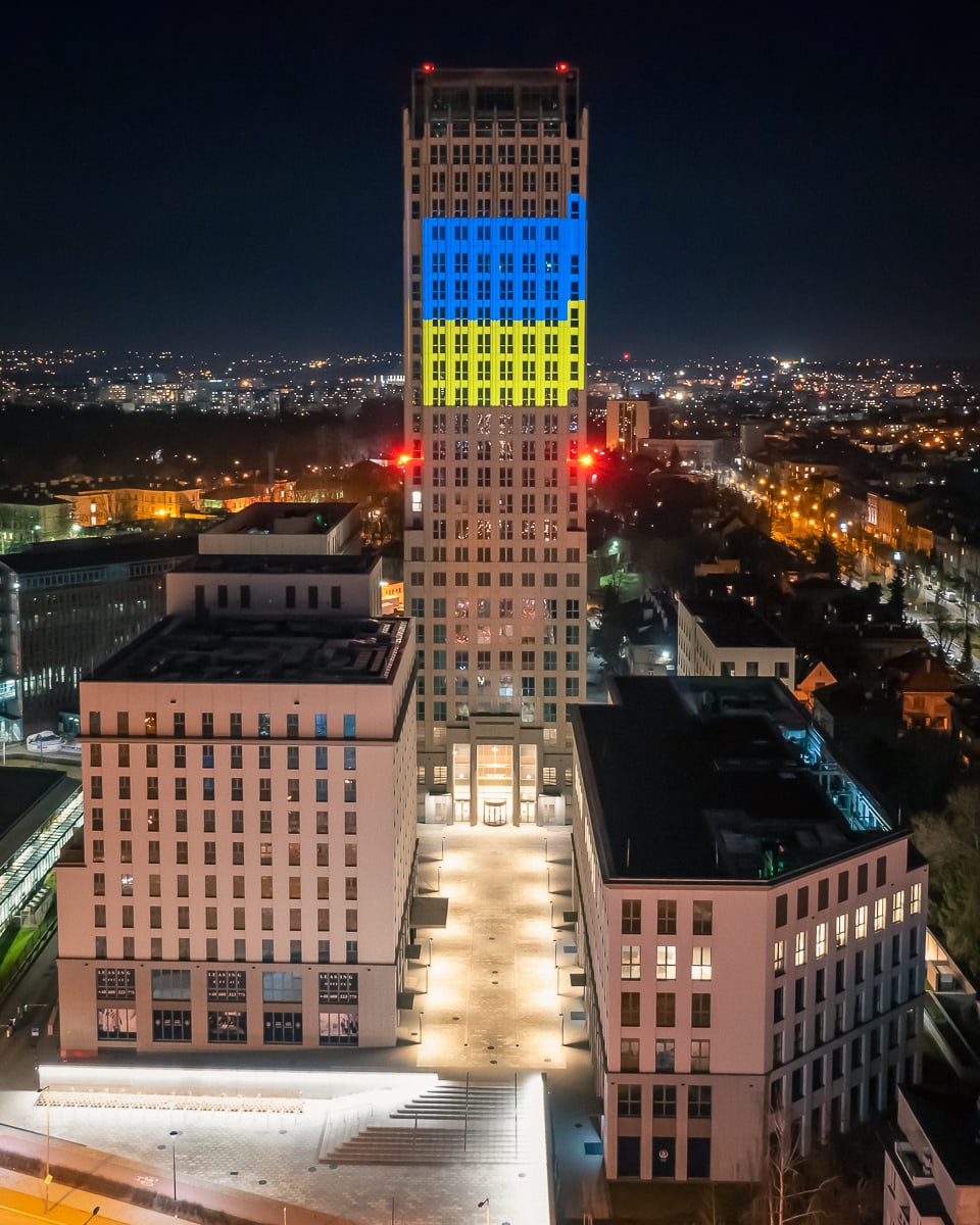 Budynek Unity Centre w Krakowie w nocy z podświetleniem w kolorach flagi Ukrainy